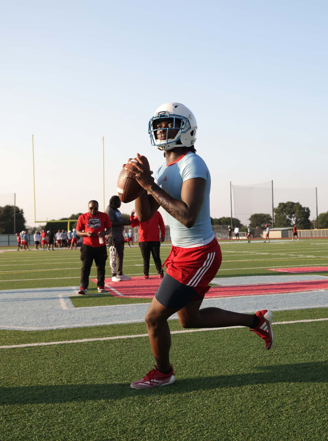 C.J. Miller throws the ball as players attend their first day of football practice at Carter...