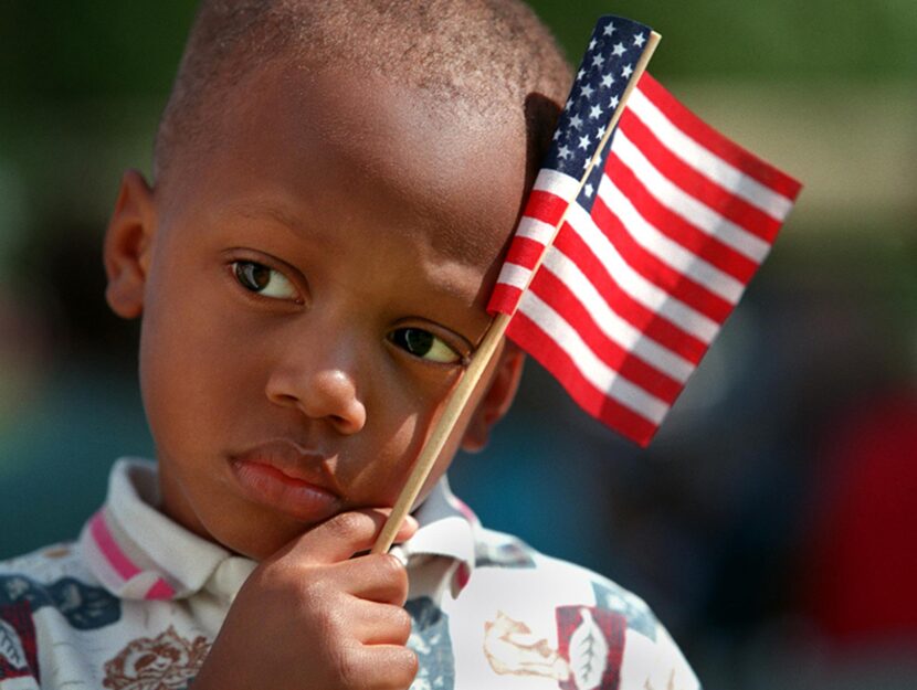  Zella Mendly, 3, of Dallas, holds the American flag during the invocation May 31, 1999 at...