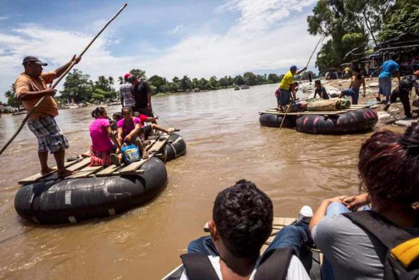 
Migrants raft across the Suchiate River from Guatemala to Mexico, landing near Ciudad...