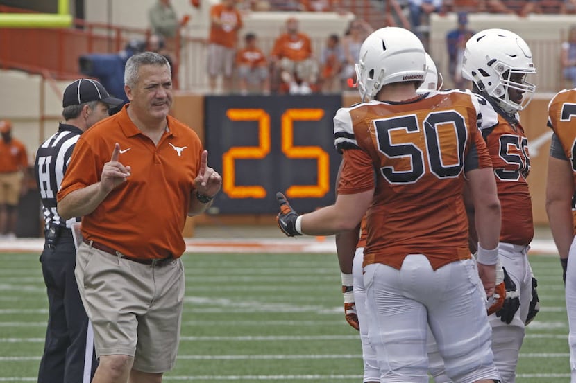 Texas offensive line coach Joe Wickline directs center Jake Raulerson (50) during the first...
