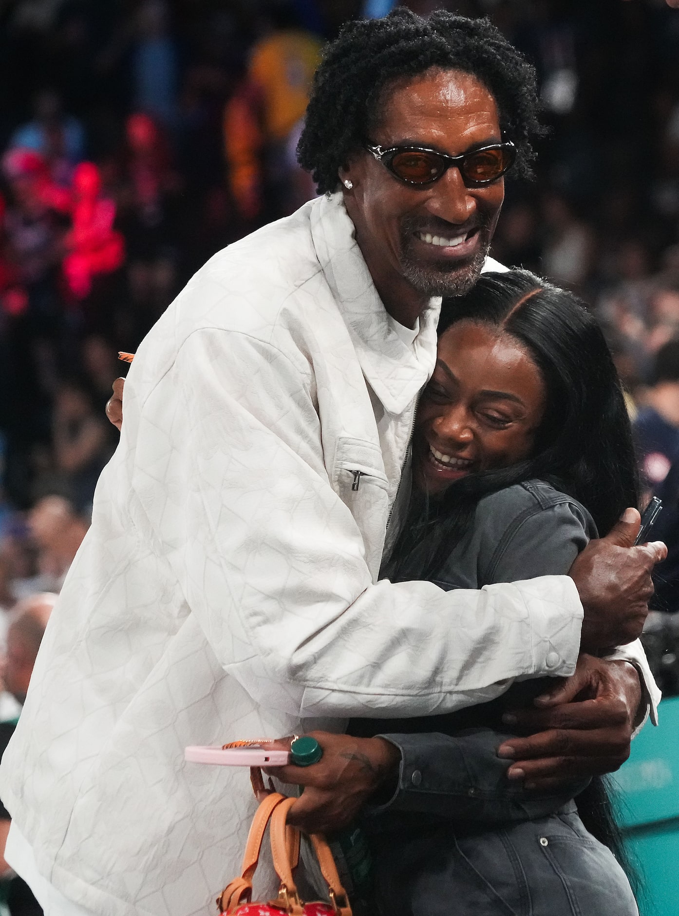 Scottie Pippen hugs Sha’carri Richardson as they watch from courtside during the men's gold...