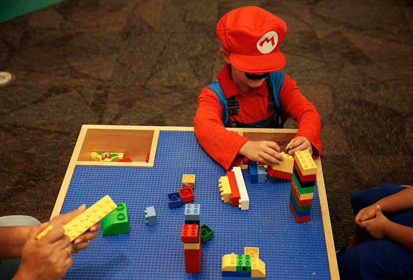  Daegin Massey, 5, of Plano, Texas, plays with blocks while dressed like the character...