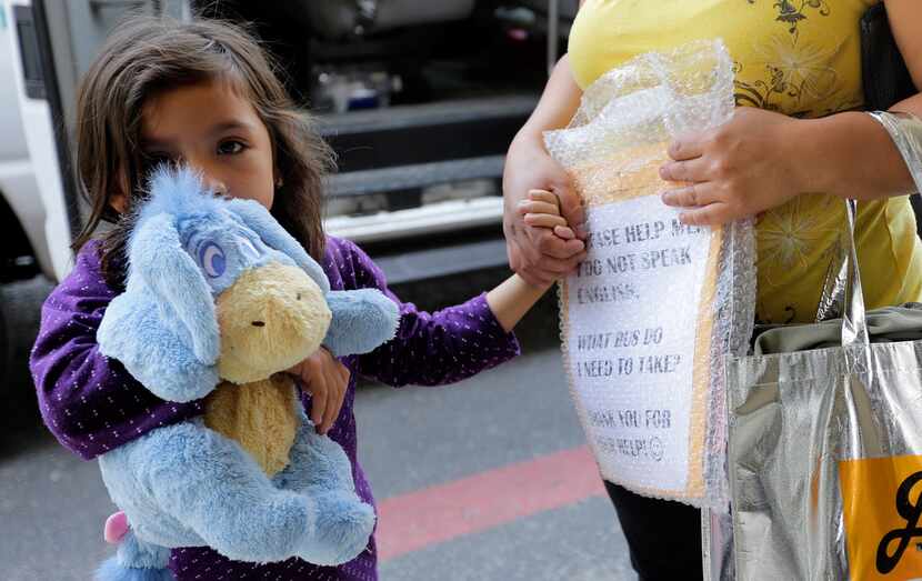 Immigrants recently released and reunited with family arrive at a Catholic Charities...