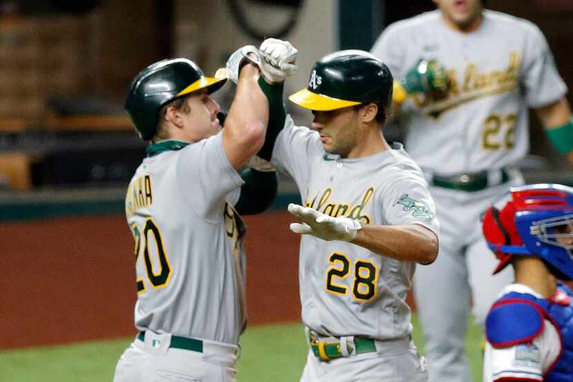 Oakland Athletics Matt Olson (28) is congratulated on his two-run homer by teammate Mark...