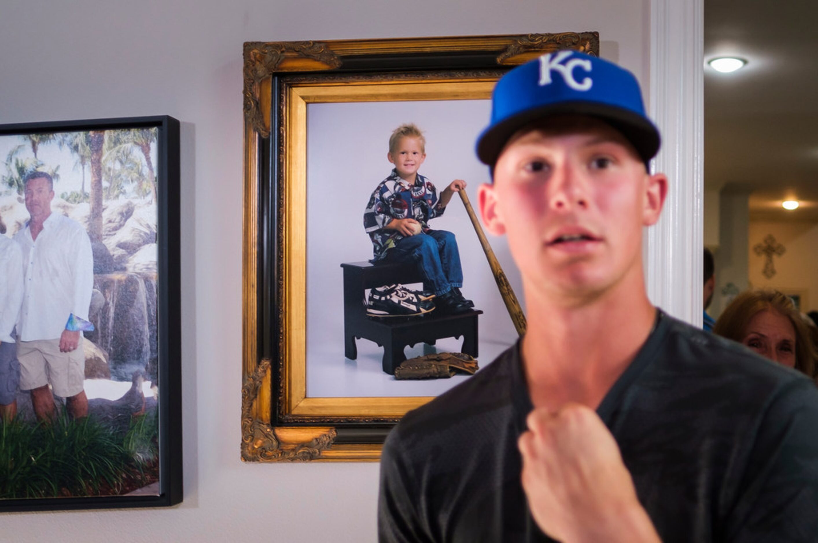 Bobby Witt Jr. passes a photo of himself at age two during a Major League Baseball draft...