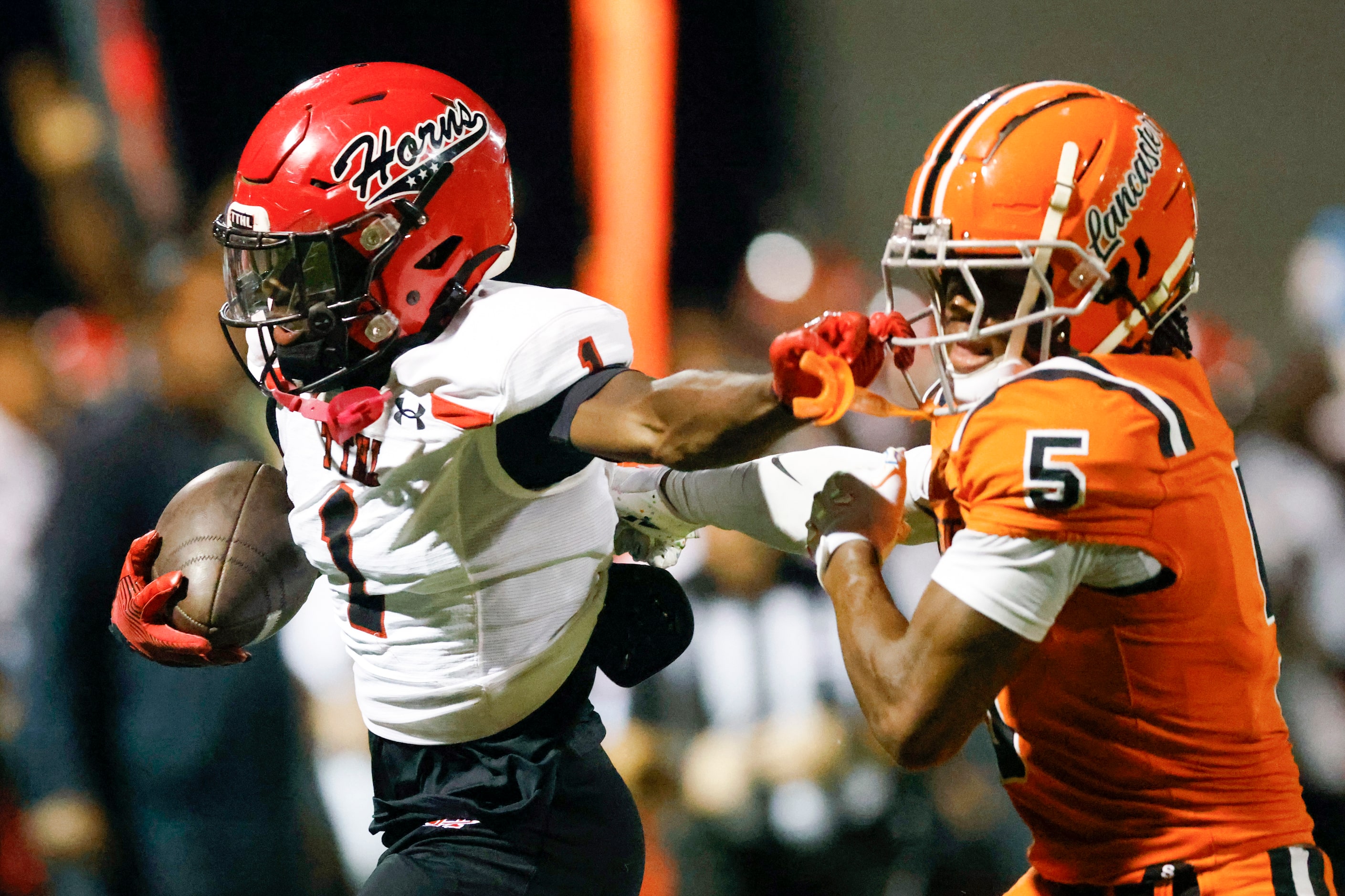 Cedar Hill wide receiver Cedric Mills (1) stiff-arms Lancaster defensive back Braylan...