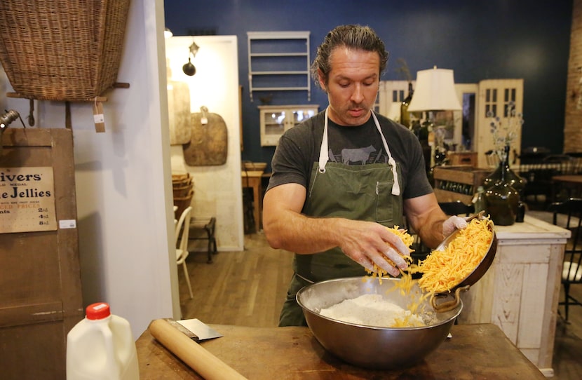 Chef Robert Lyford combines ingredients while preparing cheddar biscuits at Patina Green...