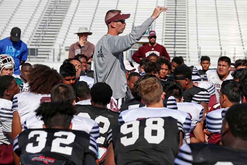 Coach Jeff Fleener speaks to his players and coaches after spring practice at Mesquite High...