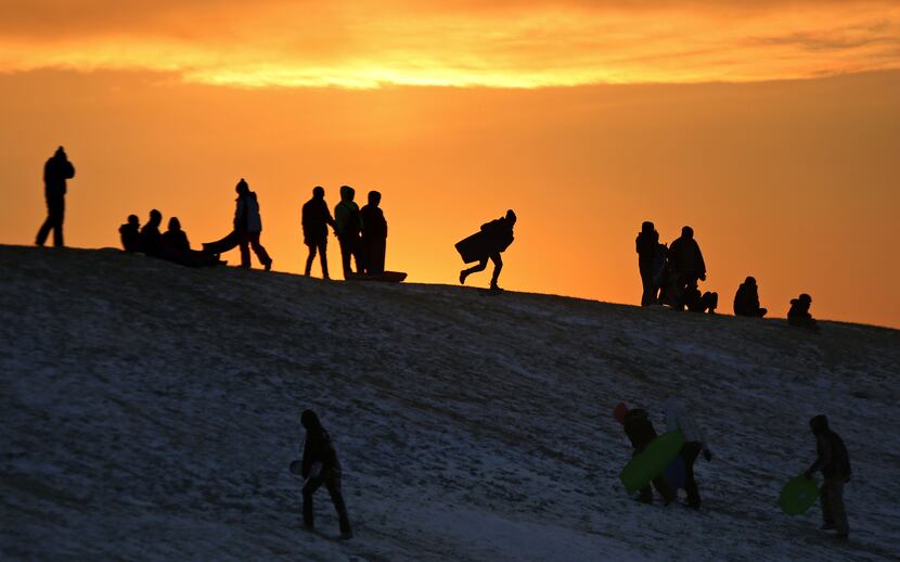 NEWPORT NEWS, VA: The sun begins to set as sledders get in their last minute rides down a...