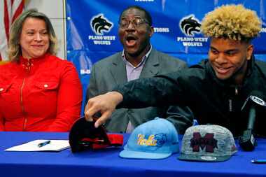 Hamed Sanogo (center) reacts as his son, Plano West linebacker Mohamed Sanogo, chooses...