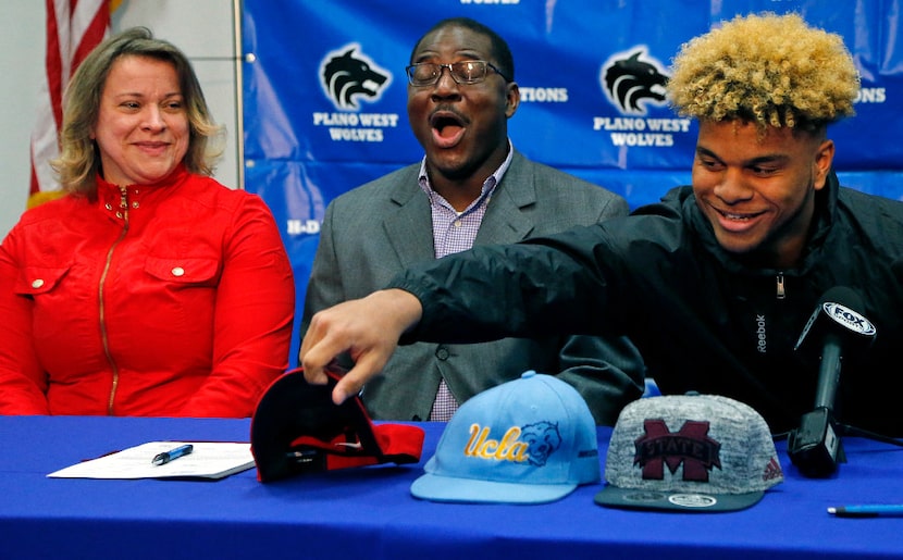 Hamed Sanogo (center) reacts as his son, Plano West linebacker Mohamed Sanogo, chooses...