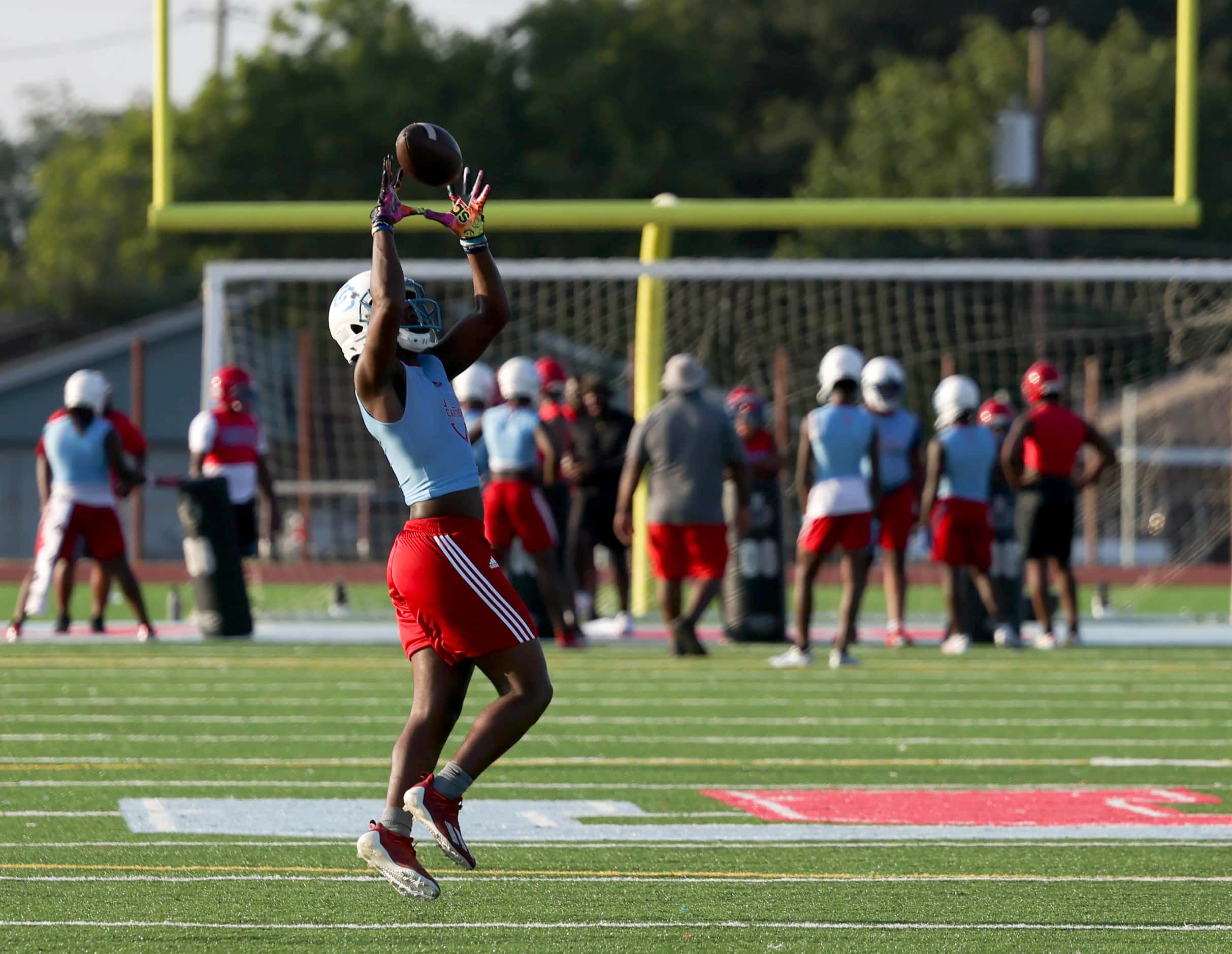 Camden Patterson jumps to catch a pass during the first football practice of the season at...
