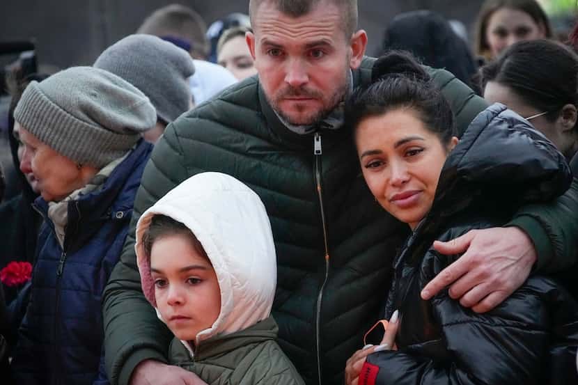 People react next to the Crocus City Hall, on the western edge of Moscow, Russia, Saturday,...