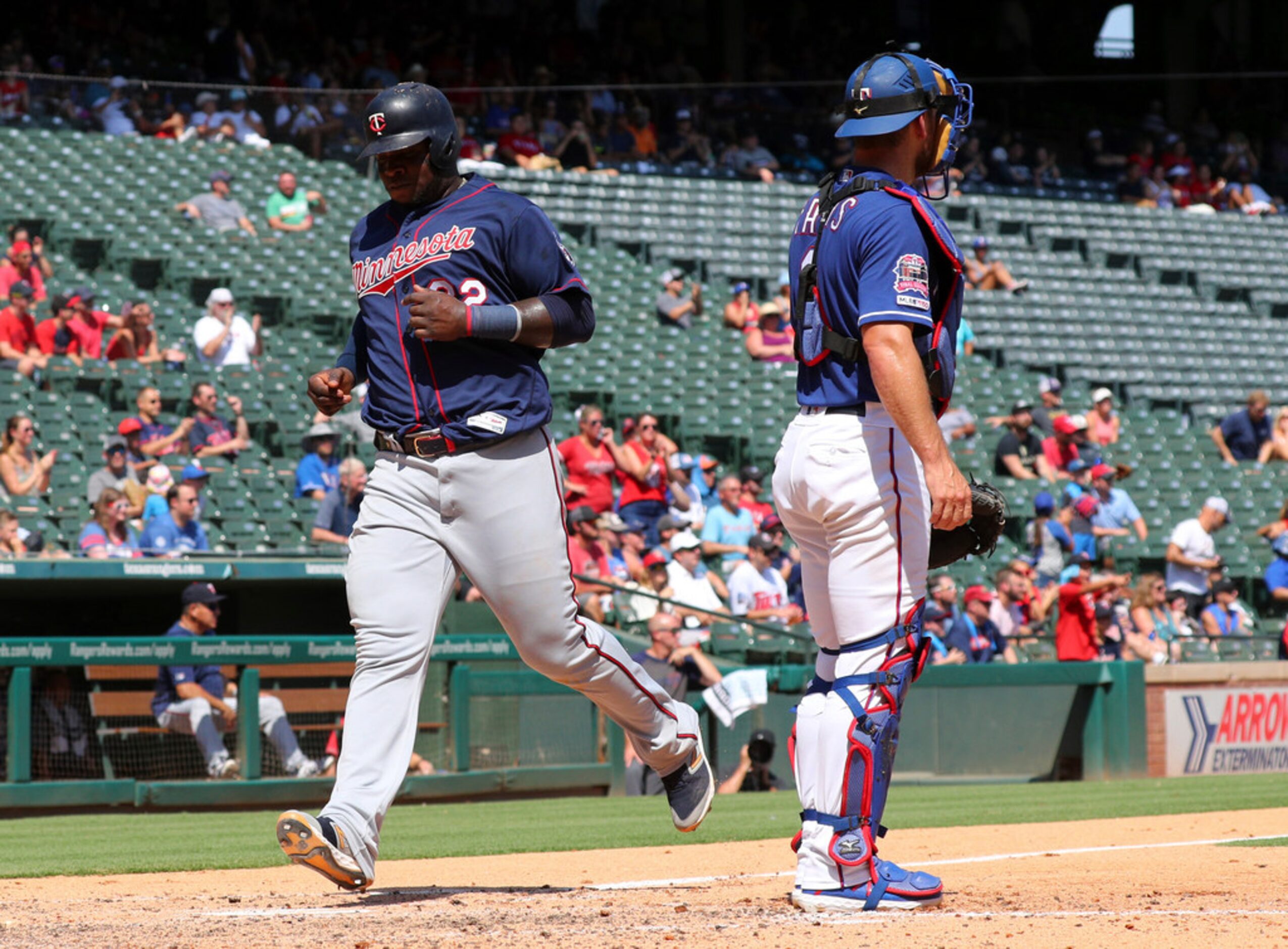 Minnesota Twins' Miguel Sano, left, scores on a sacrifice fly by Eddie Rosario in the third...