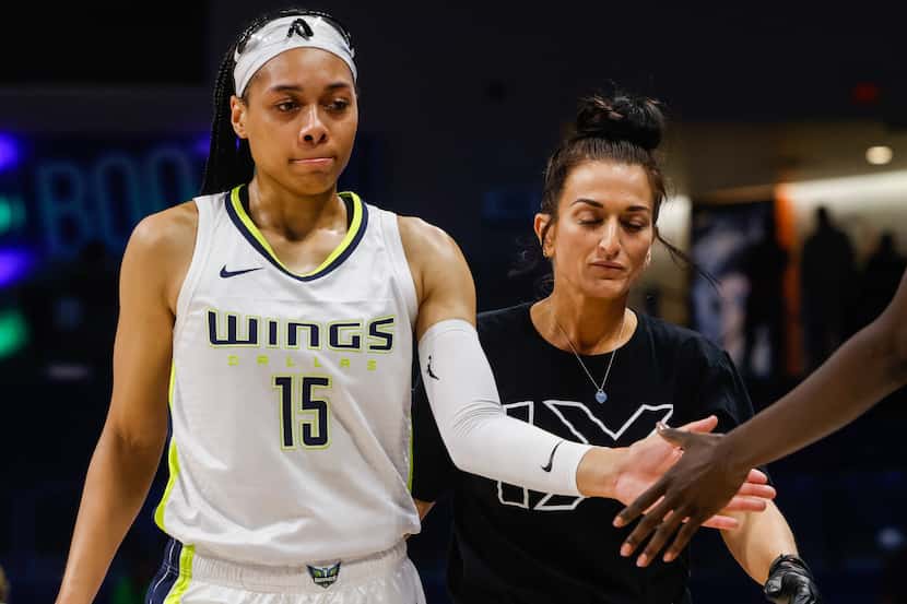 Dallas Wings guard Allisha Gray (15) leaves the court after spraining her ankle during the...