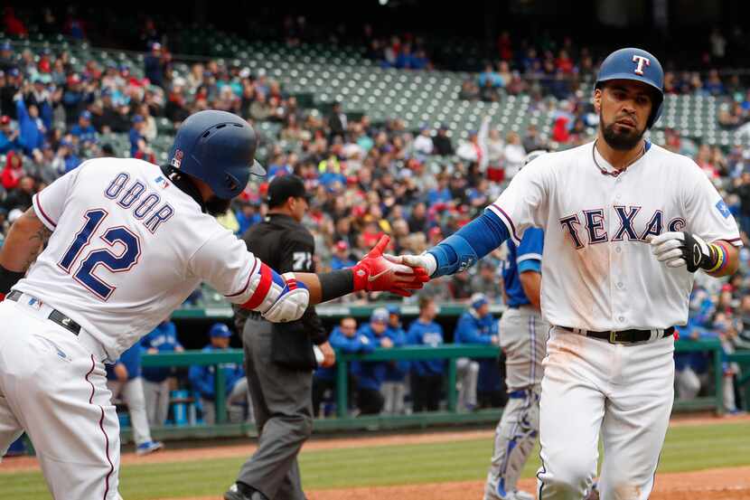Texas Rangers' Robinson Chirinos, right, is congratulated by Rougned Odor after scoring on a...