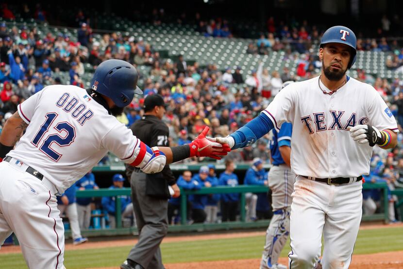 Texas Rangers' Robinson Chirinos, right, is congratulated by Rougned Odor after scoring on a...