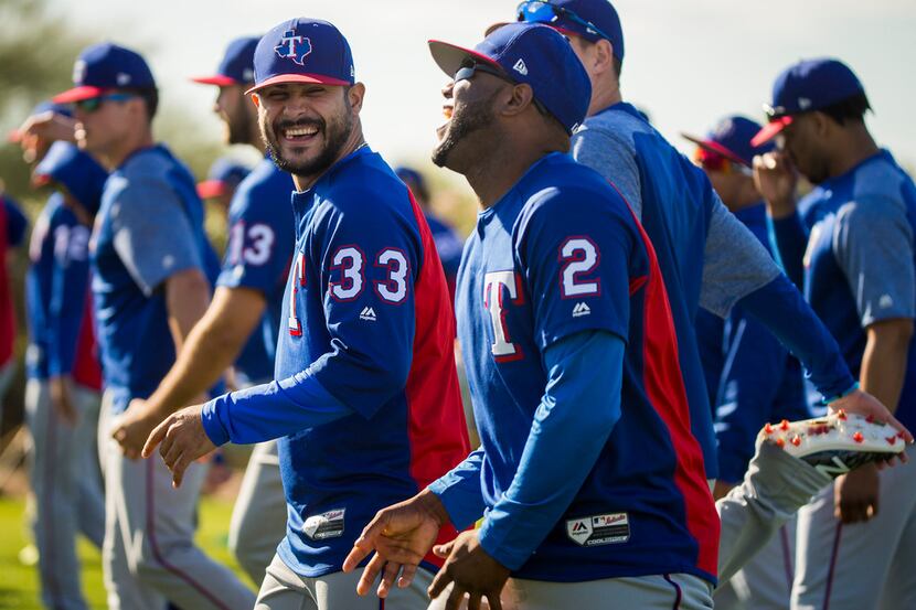 Texas Rangers pitcher Martin Perez (33) laughst with infielder Hanser Alberto (2) as they...