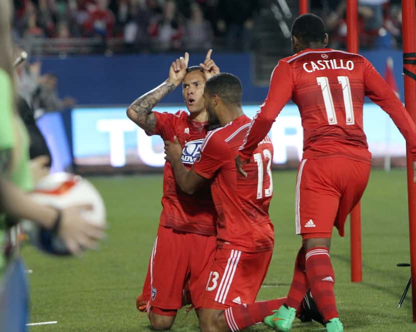 FC Dallas' Blas Perez (7) gestures to fans in the stands as he celebrates with teammates...