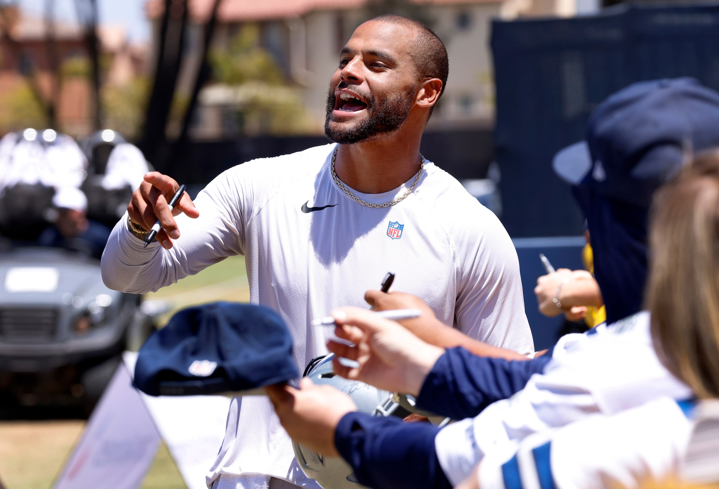 Dallas Cowboys quarterback Dak Prescott yells to his brother while singing autographs for...