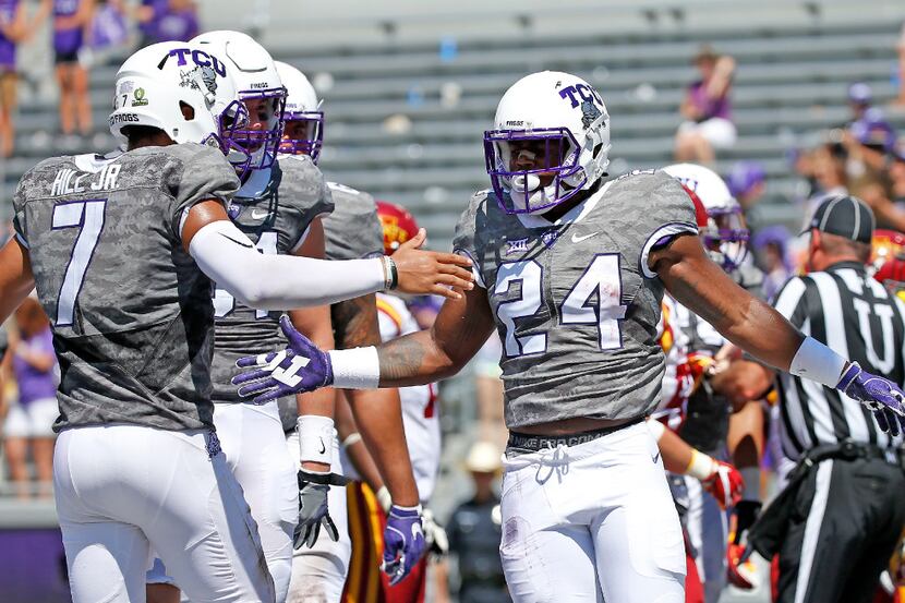 TCU running back Trevorris Johnson (24) is congratulated by quarterback Kenny Hill (7) for...