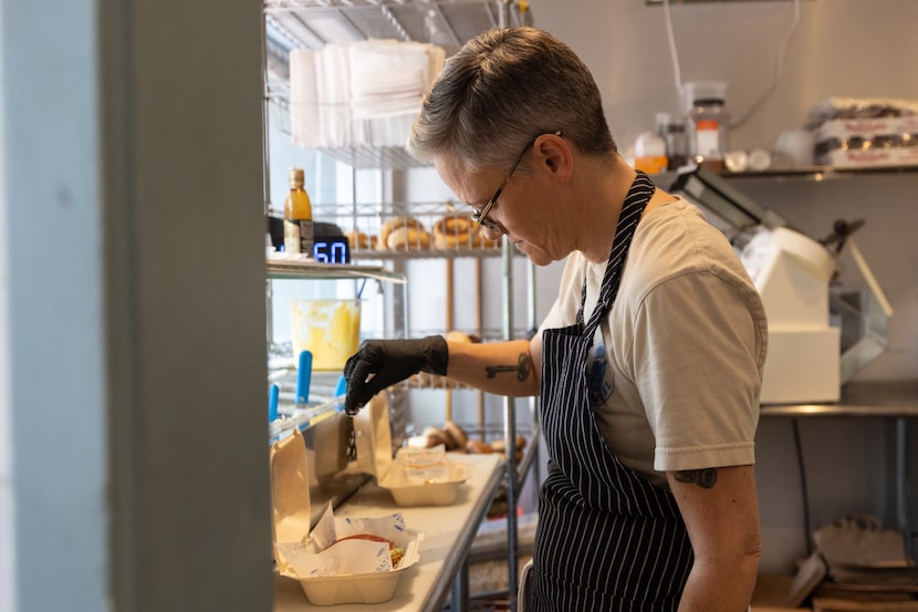 Starship Bagel sandwich maker Haley Hark preps online orders at their downtown location on...