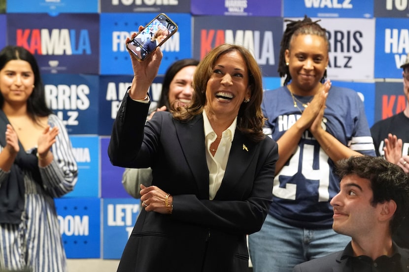 Democratic presidential nominee Vice President Kamala Harris holds up a phone as she phone...