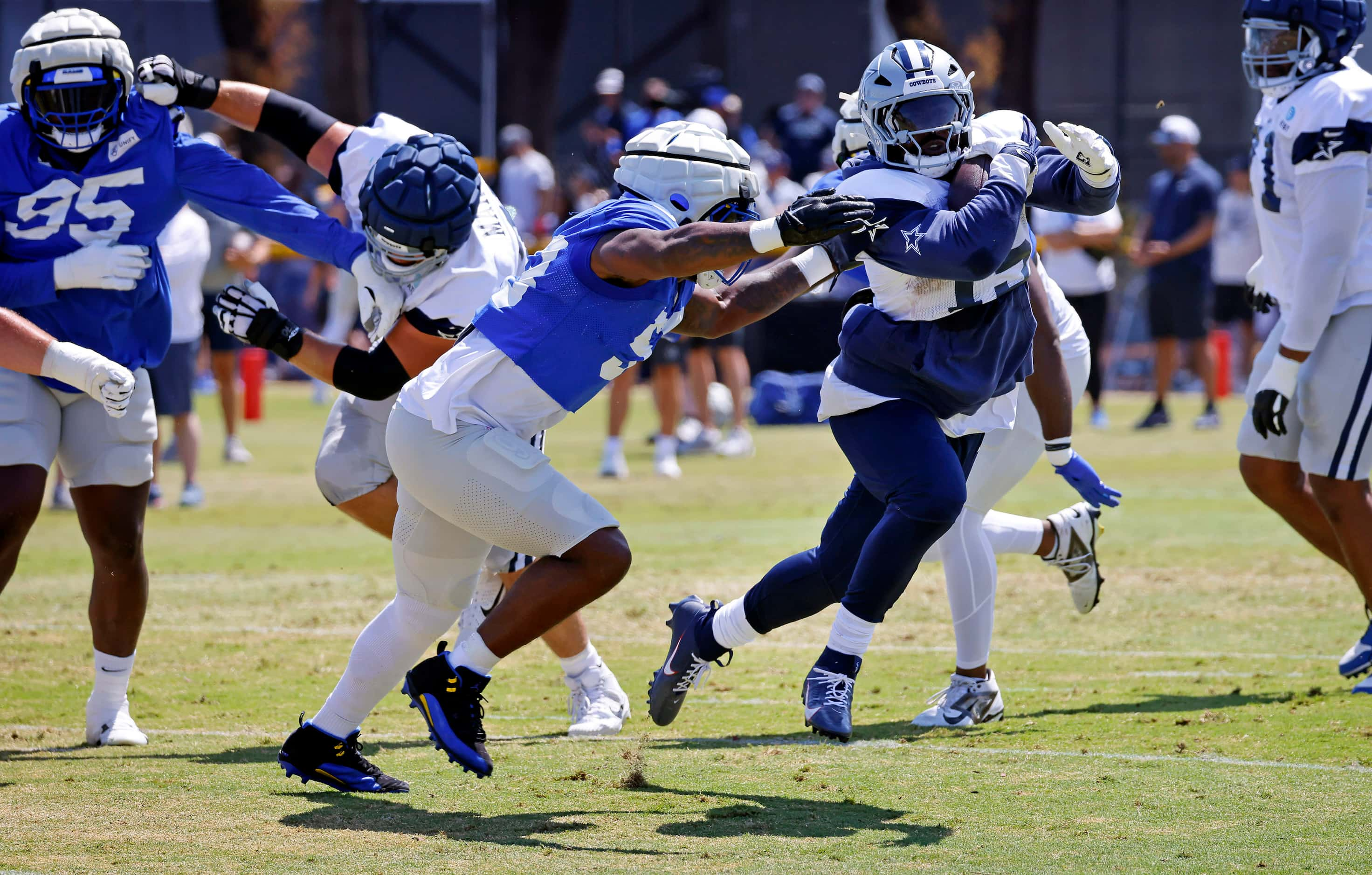 Dallas Cowboys running back Ezekiel Elliott (15) slips past Los Angeles Rams linebacker...