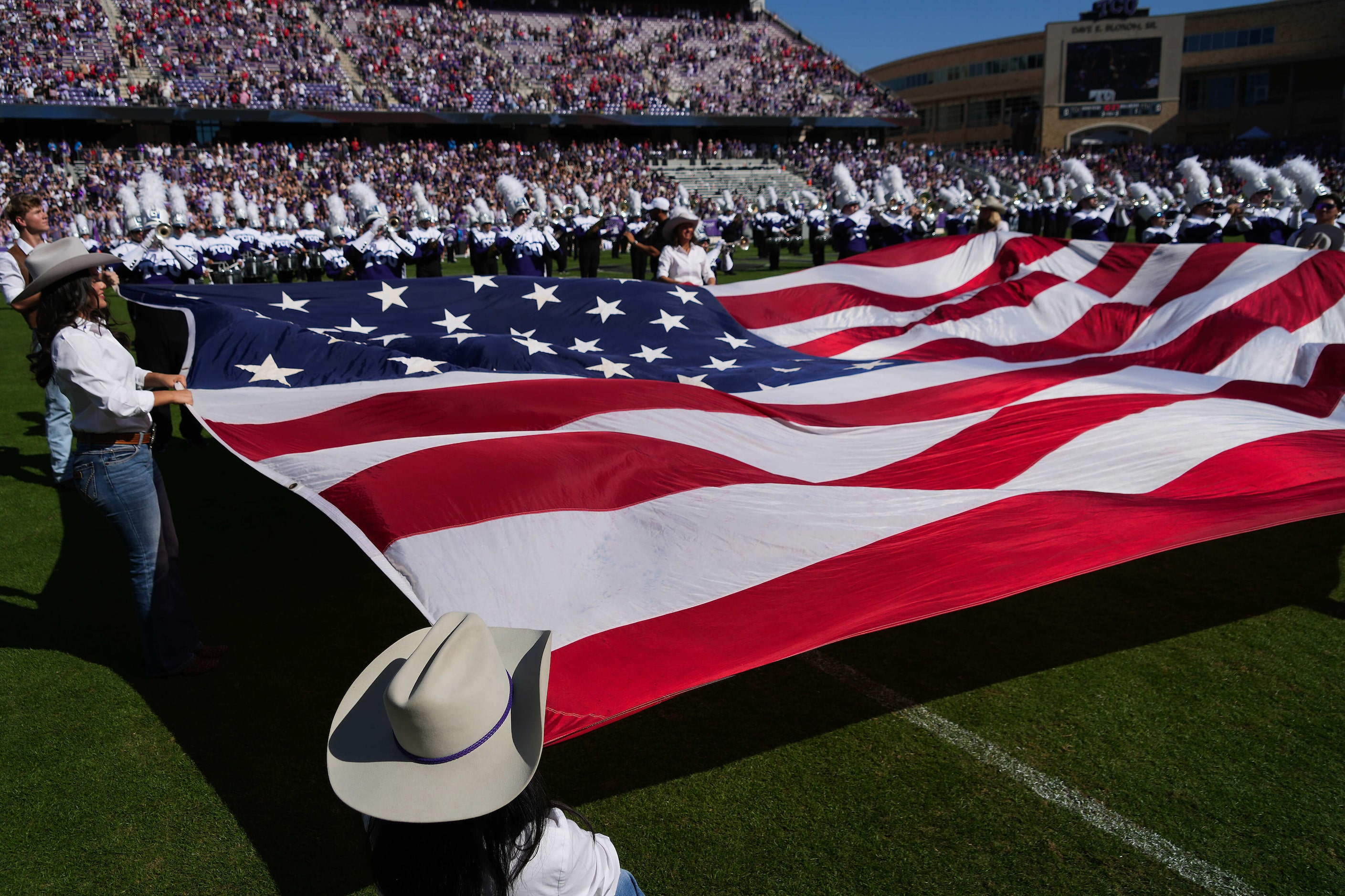 The American flag is unfurled on the field during the playing of the national anthem before...