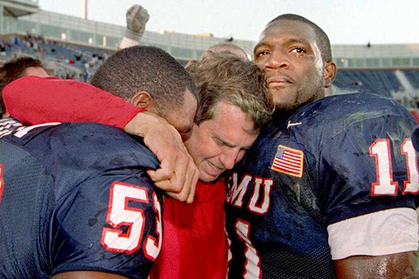  November 24, 2001--Outgoing SMU football coach Mike Cavan (middle) cries with his players...