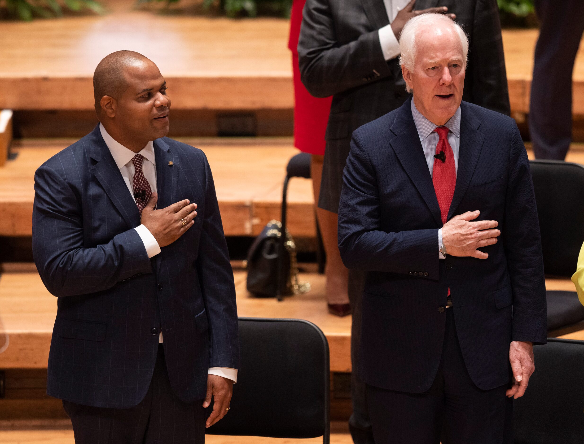 Dallas Mayor Eric Johnson and U.S. Sen. John Cornyn stand for the pledge of allegiance...