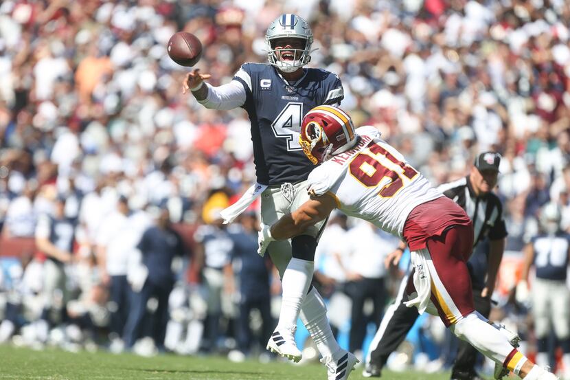Dallas Cowboys quarterback Dak Prescott (4) makes a pass under pressure from Washington...