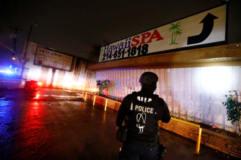 A Dallas Police vice officer inspects the outside of Jade Spa, until last week's raid one of...