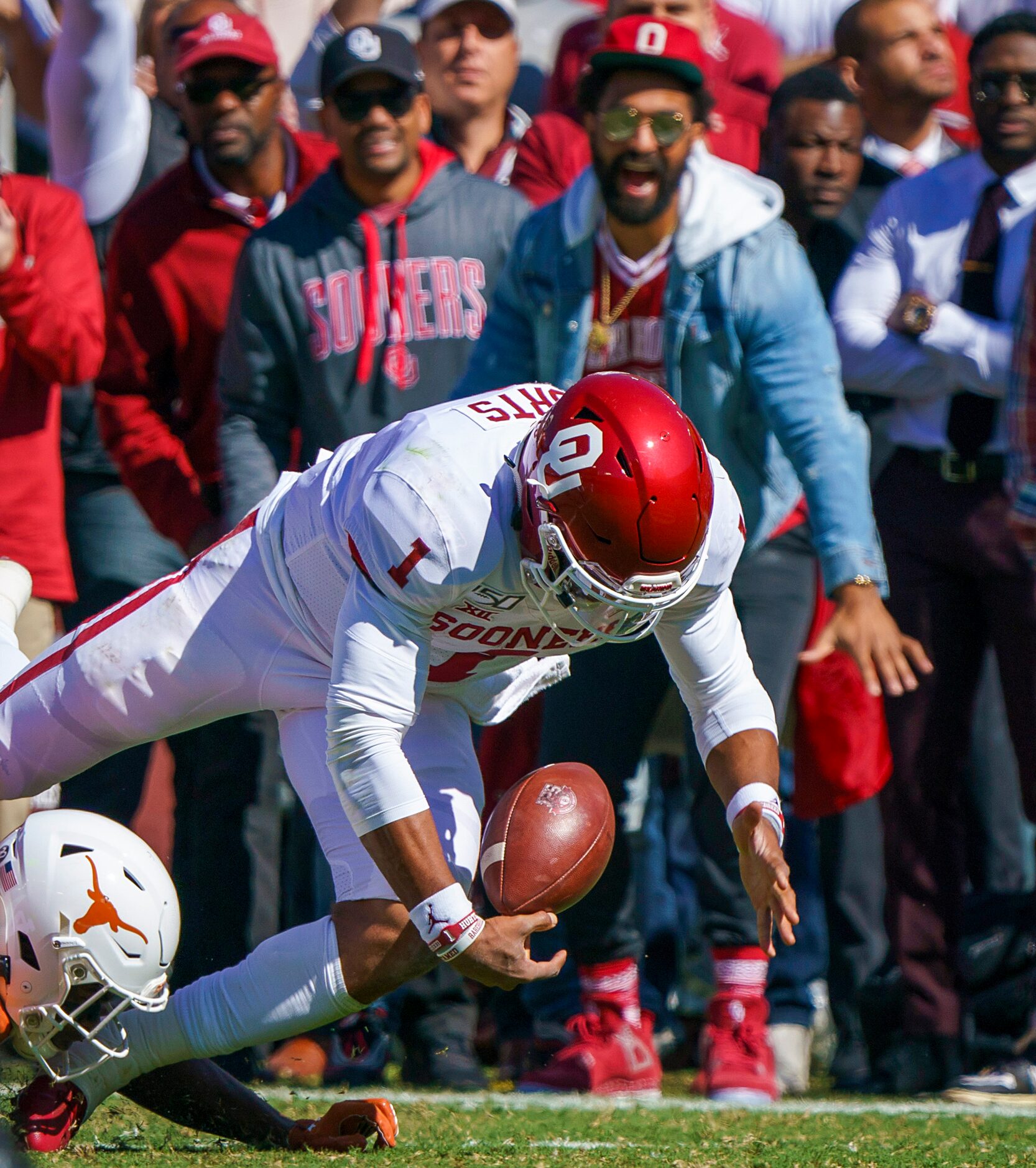 Oklahoma quarterback Jalen Hurts (1) turns the ball over with a fumble after a hit by Texas...