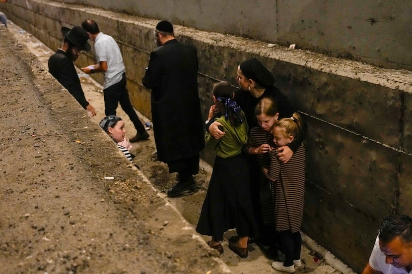 People take cover on the side of the road as a siren sounds a warning of incoming missiles...