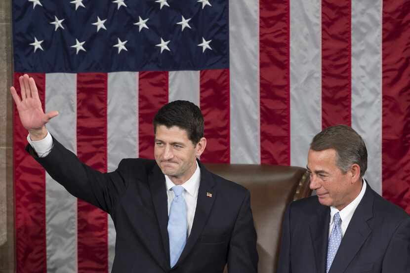 Newly-elected speaker of the House Paul Ryan waves alongside outgoing speaker John Boehner...