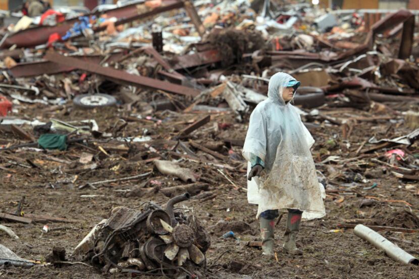 Christine Hammond looks through in the debris behind a friend's home along SW 6th Street in...