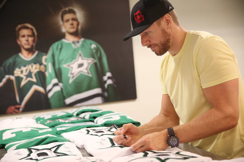 Dallas Stars defenseman Marc Methot signs autographs following the conclusion of the...