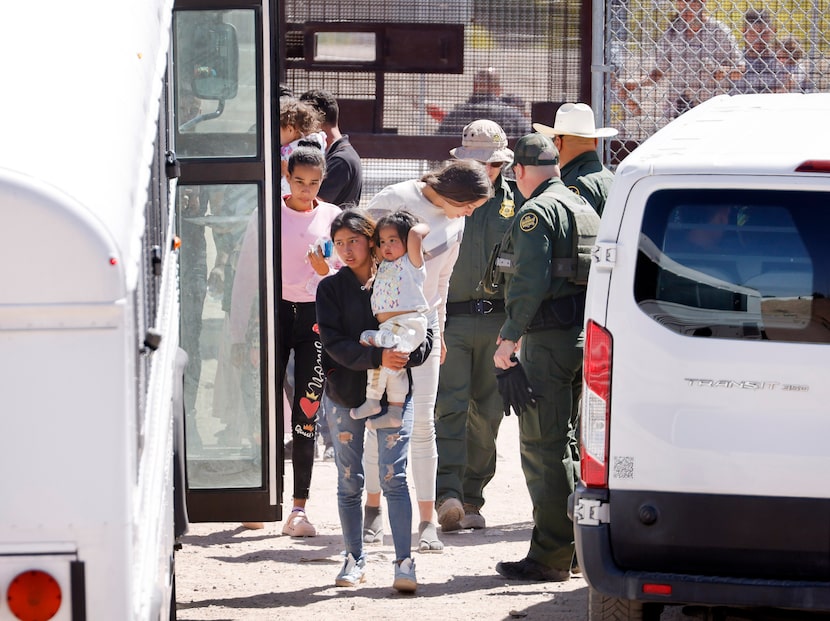 Migrant people board a waiting bus after settling on the U.S. side of the Rio Grande River,...