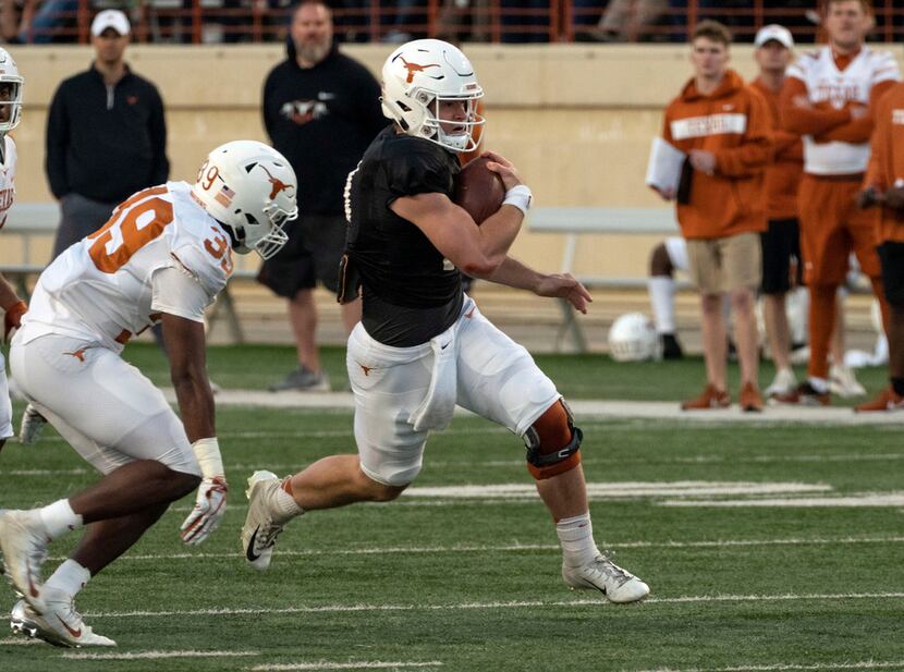 University of Texas quarterback Sam Ehlinger (11) is chased down by defensive back Montrell...