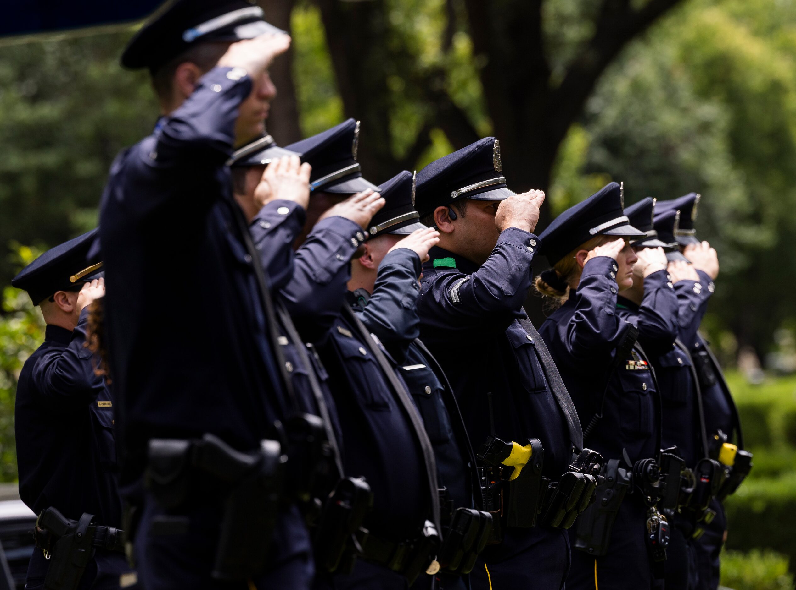 Dallas Police Department officers salute as the department renders full line-of-duty death...