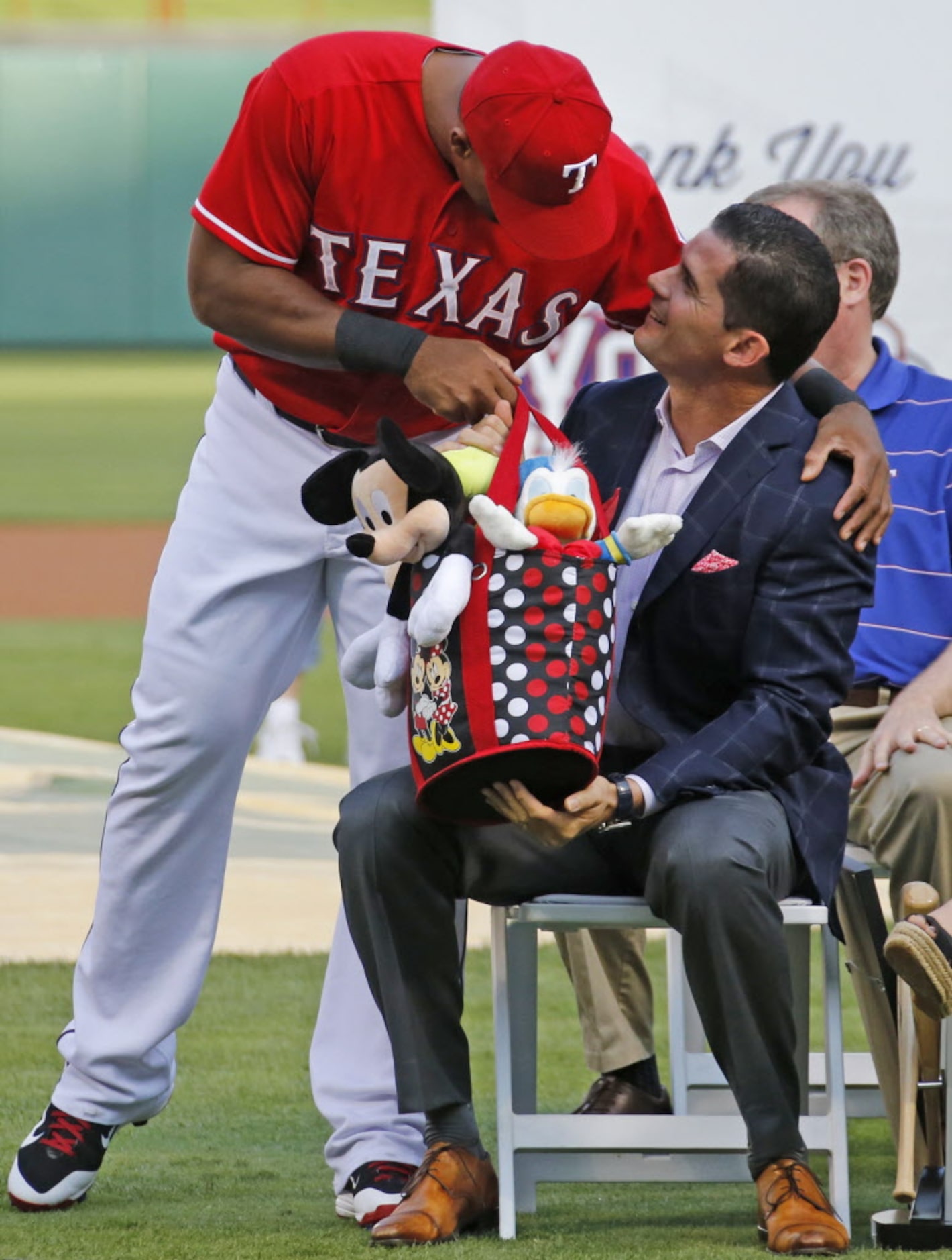 Texas third baseman Adrian Beltre presents a bag of stuffed Disney toys to former Texas...