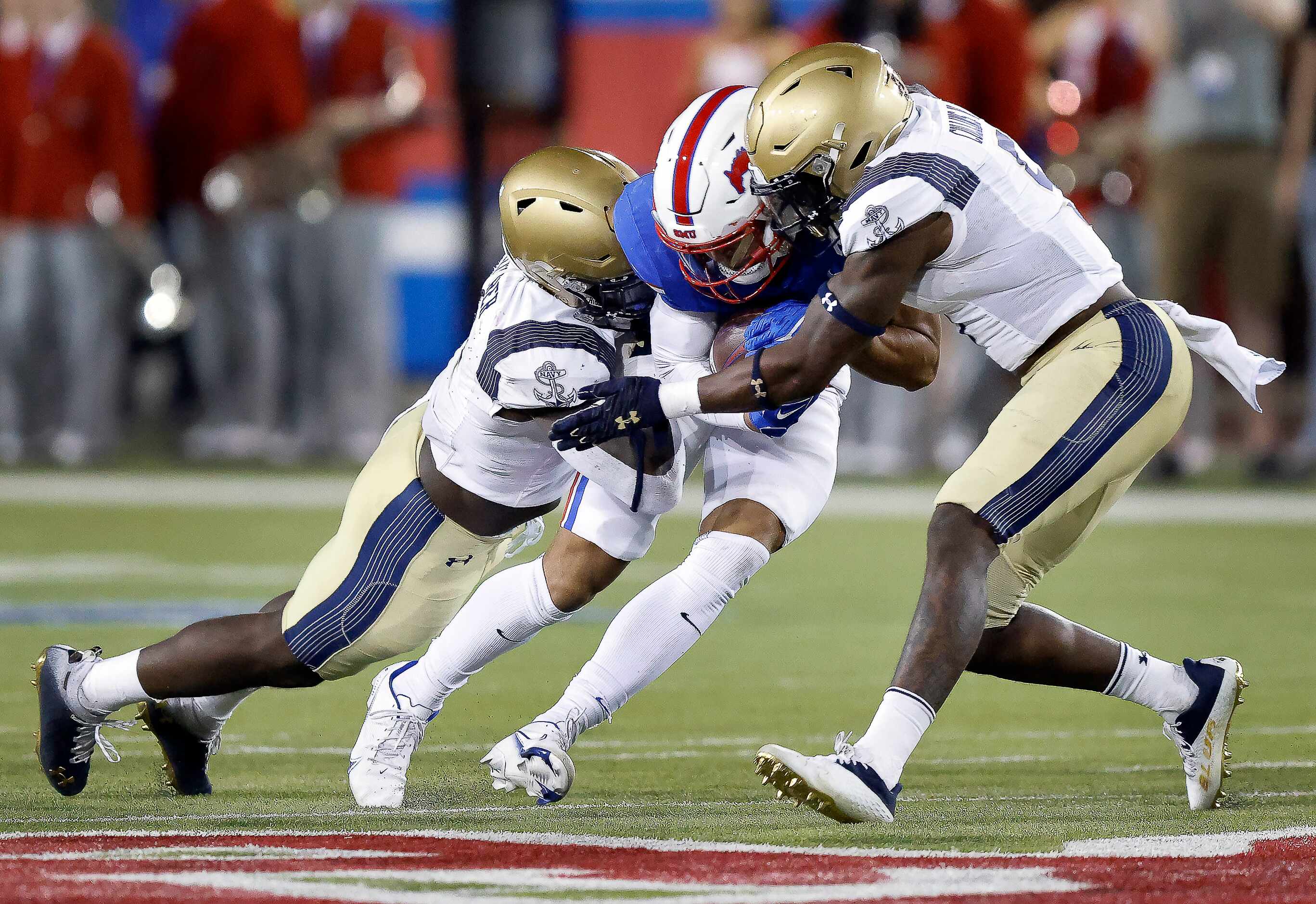 Southern Methodist Mustangs tight end Kam Allen (83) is wrapped up by Navy Midshipmen...