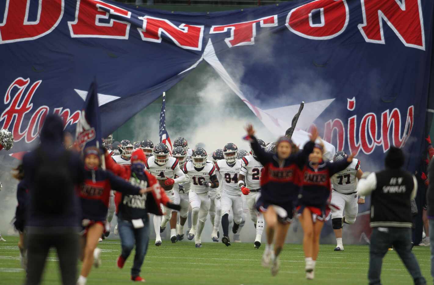 Denton Ryan players storm the field as they run through their team sign prior to the opening...