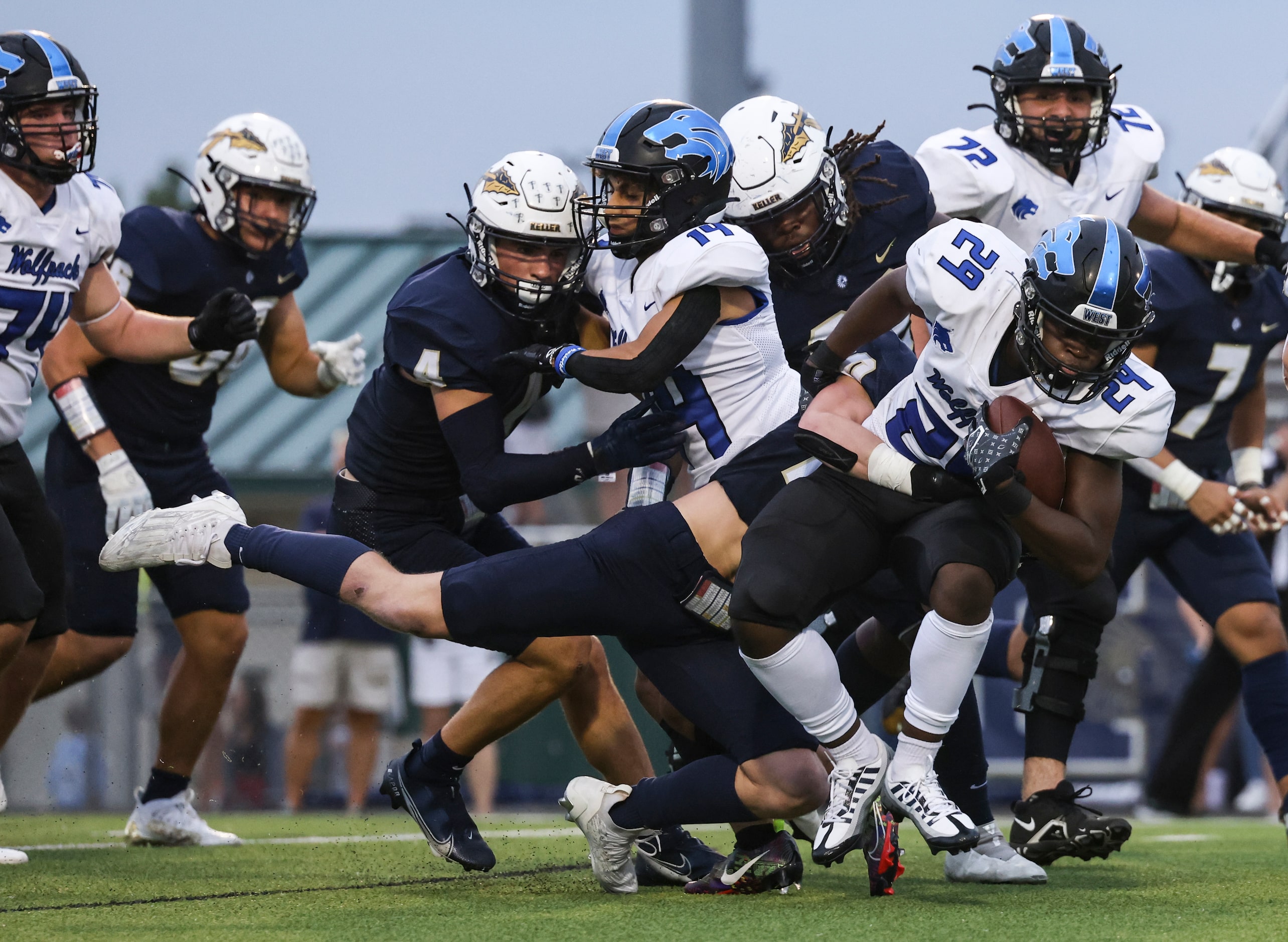 Keller High School Jay Powitz (20) tackles Plano West Senior High Suwi Musanda (29) during...