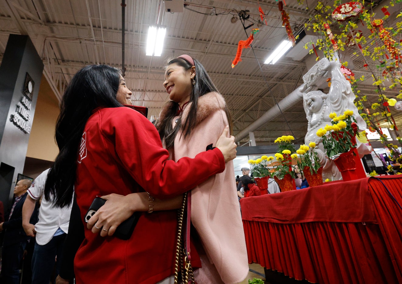 Michelle Tran, Vietnamese descendant, of Las Colinas, left, greets her friend June Loh,...