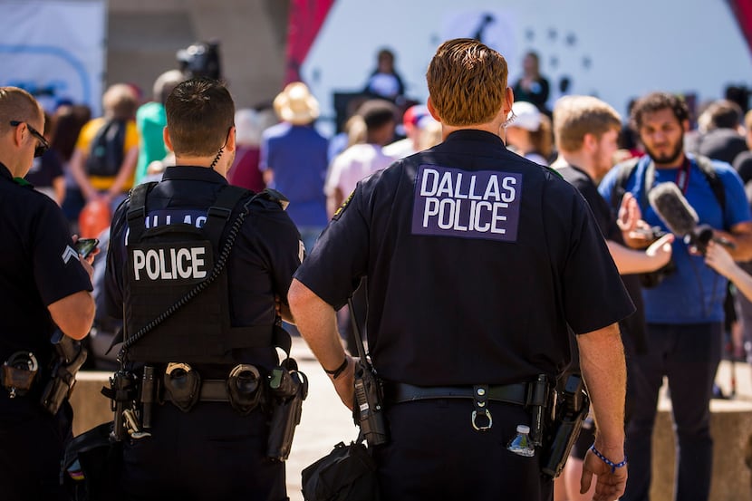 Dallas police keep an eye on gun control advocates outside Dallas City Hall during the NRA...