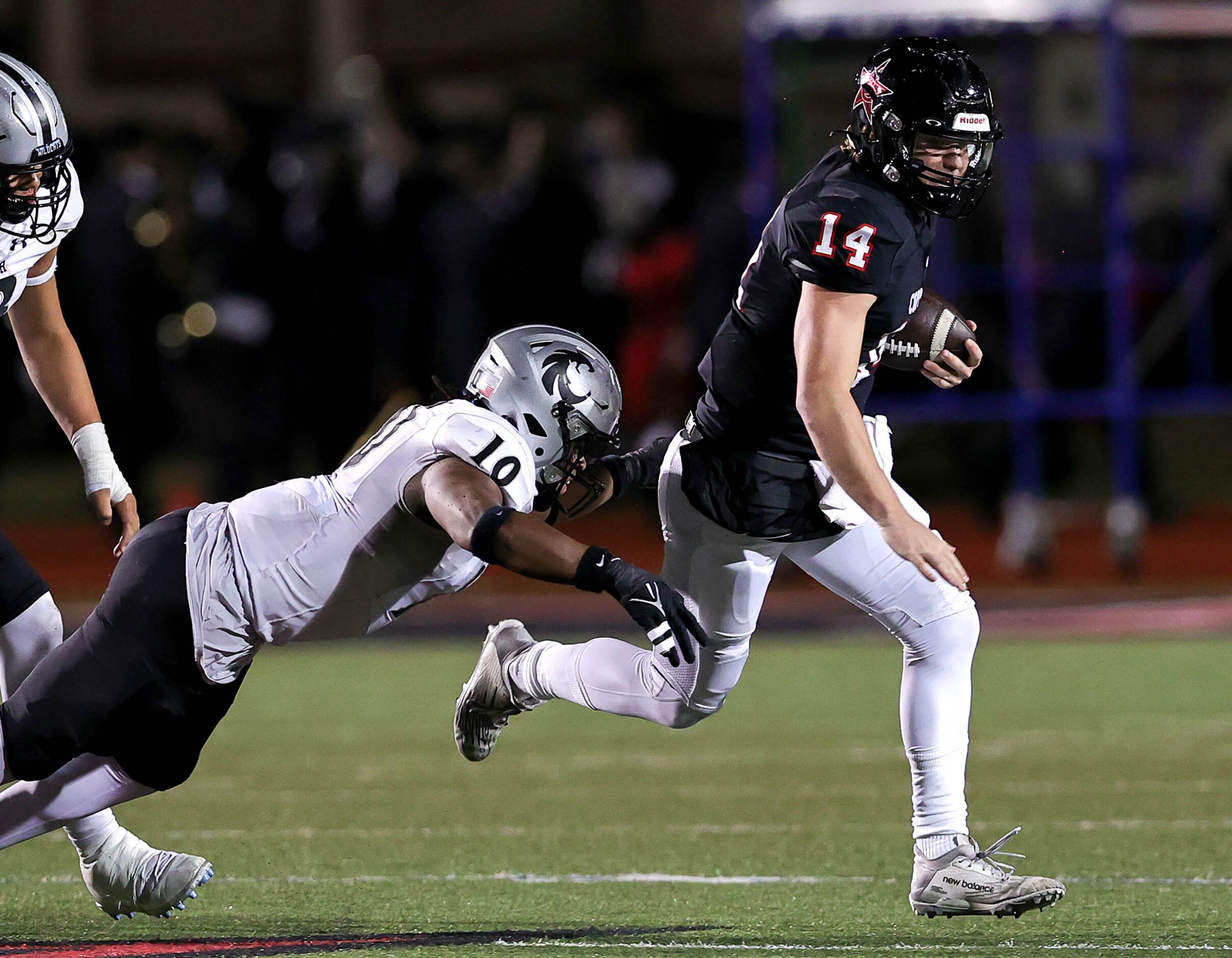 Coppell quarterback Edward Griffin (14) tries to elude Denton Guyer linebacker Caleb...