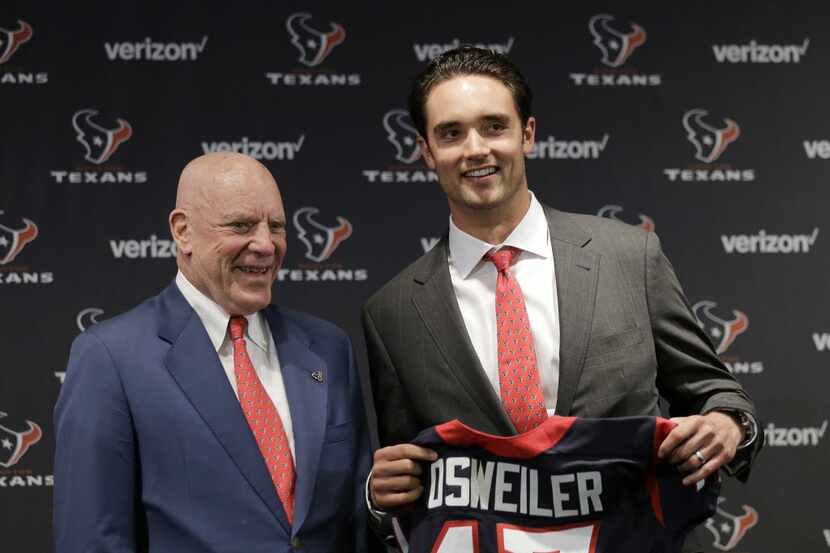 Houston Texans quarterback Brock Osweiler, right, holds his new jersey as he poses with...