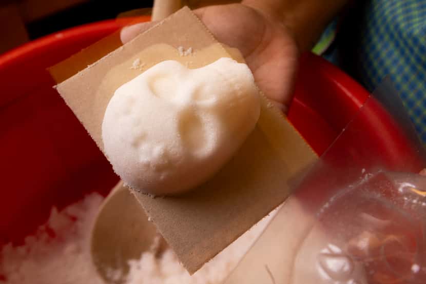 North Texas artist Maggie Wolters-Williams takes a sugar skull out of a mold at her home in...
